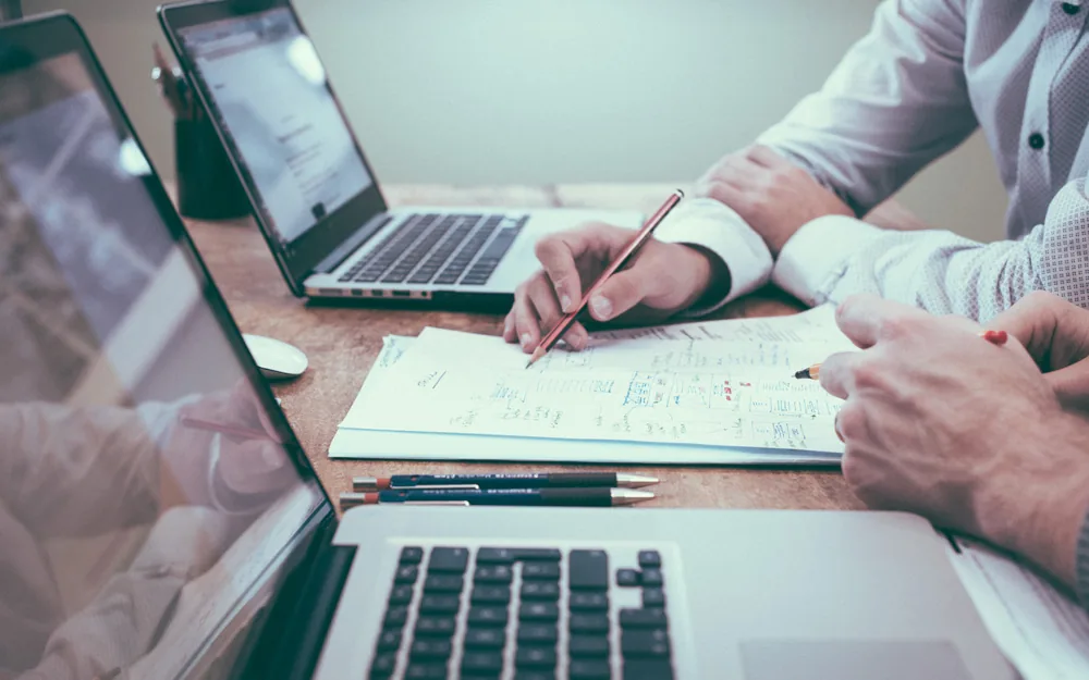 Two people reviewing business accounts together at a desk